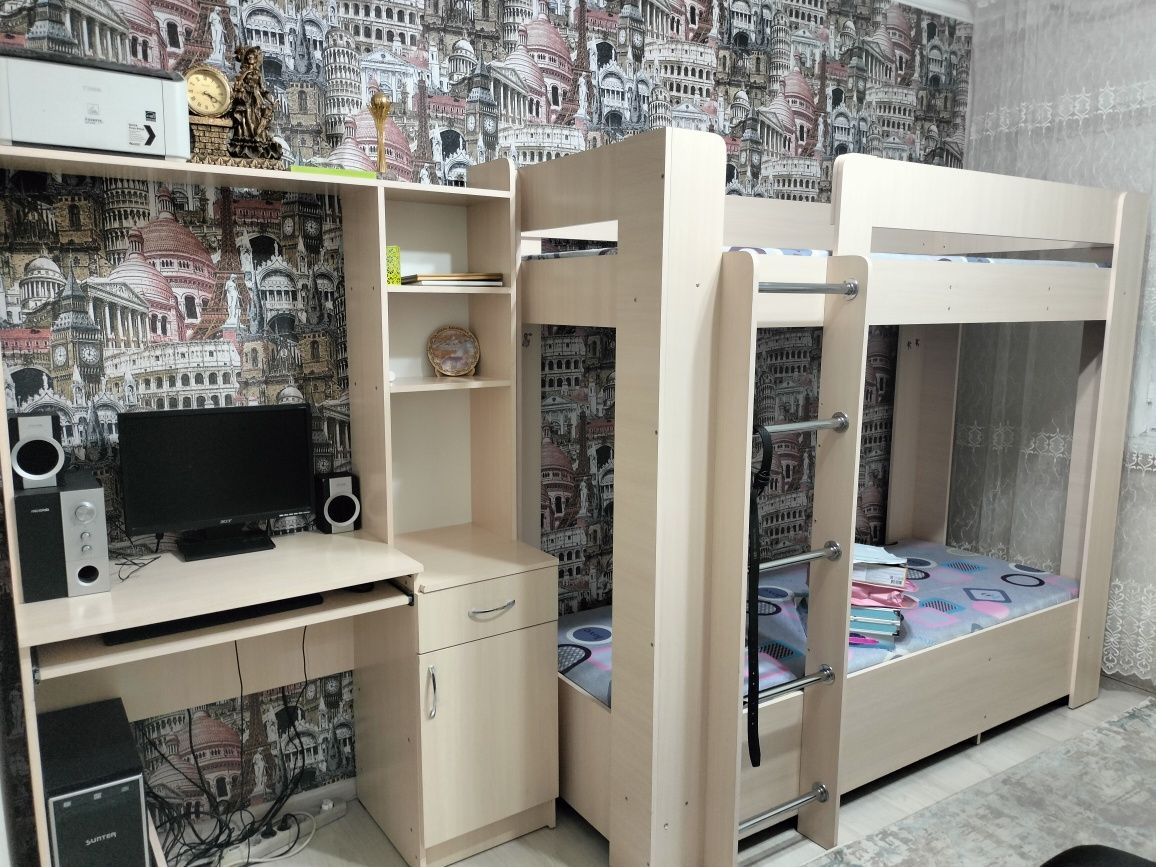 Детский кровать и компьютерный столик в месте.
