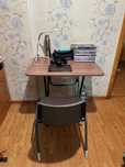 A wooden table, with comfortable chair, and a study lamp
