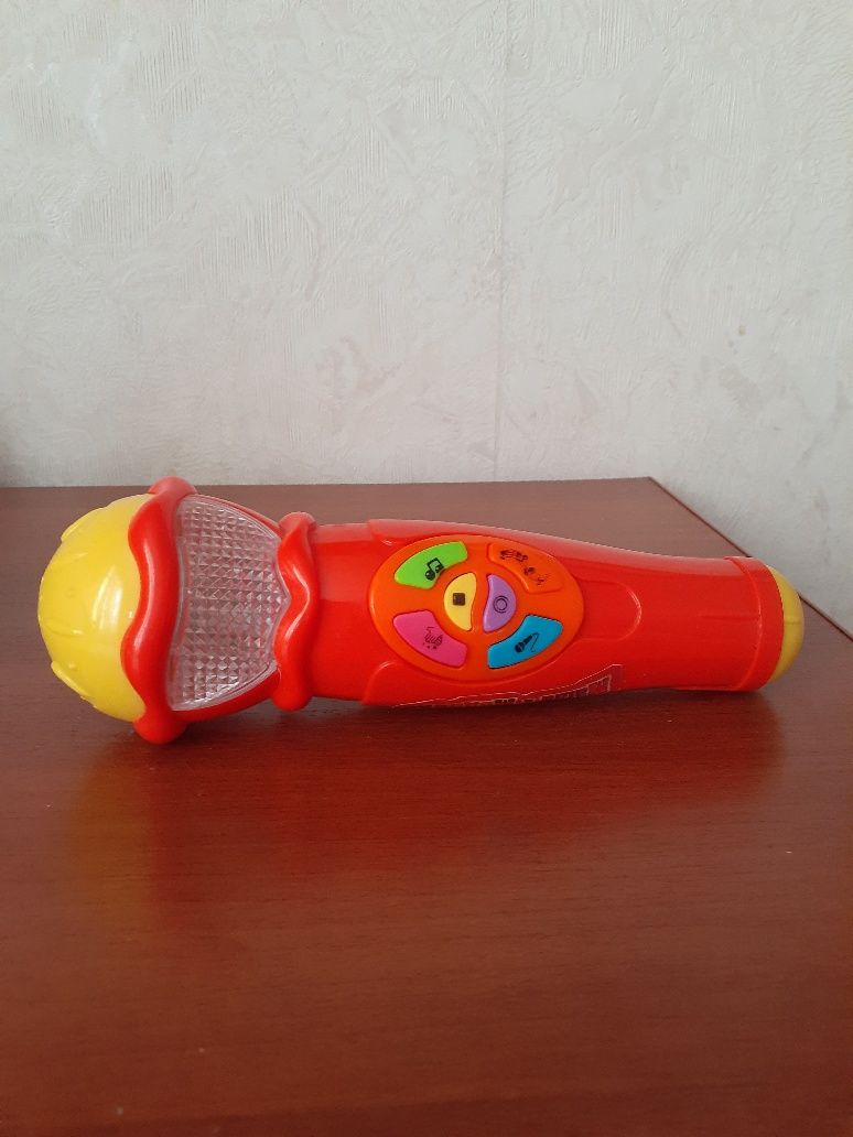 Игрушки- микрофон и динозаврик.