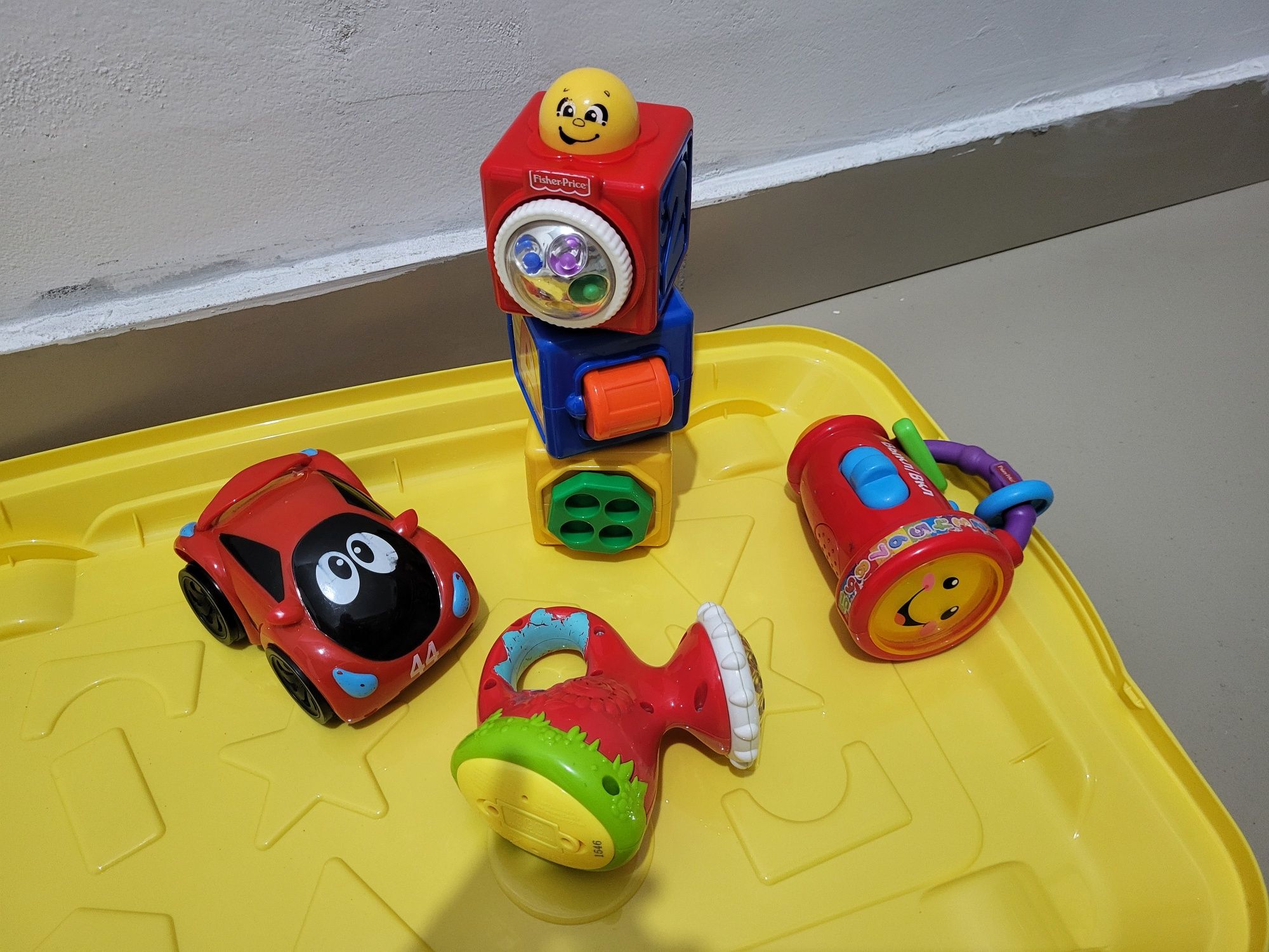 Игрушки Chicco и Fisher Price в контейнере.